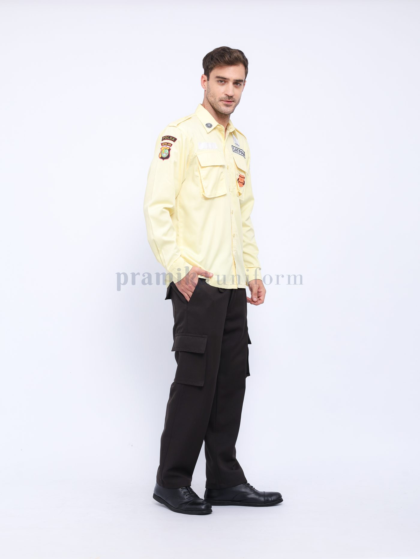 Seragam security krem dengan atribut badge dan papan nama